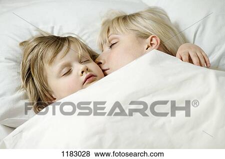 Stock Photo - A mother and her young daughter sleeping a bed side by side. Fotosearch