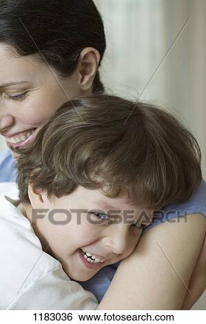 Stock Photograph - A mother and her young son hugging and laughing. Fotosearch