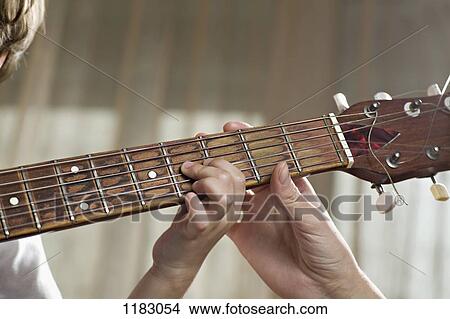 A mother helping her young son with playing an acoustic guitar View Large Photo Image Picture - A mother helping her young son with playing an acoustic guitar. Fotosearch