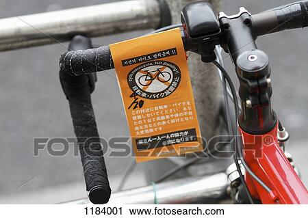 Stock Image - A "No Standing" parking ticket for bicycle in English and Japanese. Fotosearch