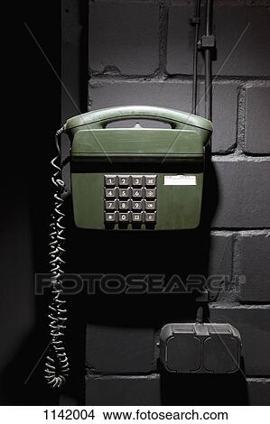 Picture - A old-fashioned telephone on a wall. Fotosearch