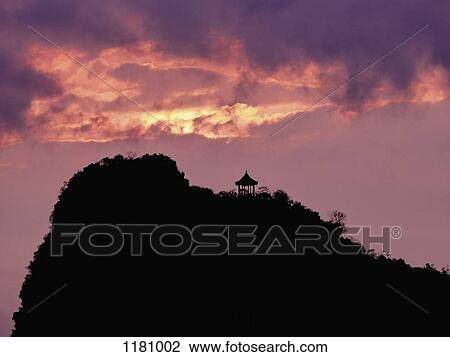 A pagoda on a hill in silhouette against a dramatic sky, Guilin River, Guilin, China View Large Photo Image Stock Image - A pagoda on a hill in silhouette against a dramatic sky, Guilin River, Guilin, China. Fotosearch