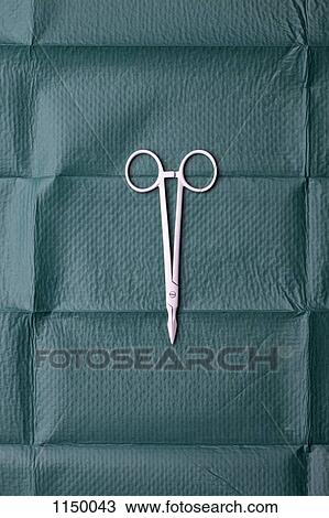 Stock Image - A pair of surgical scissors on a surgical drape. Fotosearch