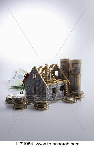 A partially constructed house with European Union currency and coins around it View Large Photo Image Picture - A partially constructed house with European Union currency and coins around it. Fotosearch