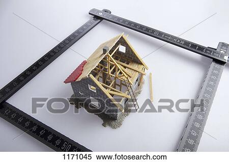 Stock Photography - A partially constructed model of a house and a folding ruler. Fotosearch