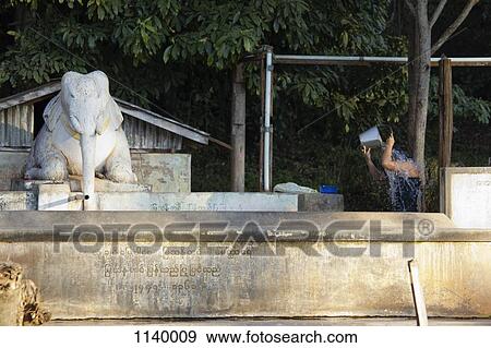A person washing hair with a bucket next to an elephant statue, Heho, Burma View Large Photo Image Stock Photo - A person washing hair with a bucket next to an elephant statue, Heho, Burma. Fotosearch