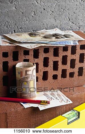 A pile of money on stacked bricks with a pencil and level View Large Photo Image Stock Image - A pile of money on stacked bricks with a pencil and level. Fotosearch