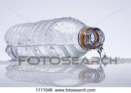 Stock Photograph - A plastic water bottle lying on its side, water spilling out. Fotosearch