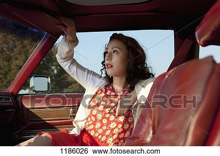 A pretty rockabilly woman pulling a sun visor down in a vintage car View Large Photo Image Stock Photograph - A pretty rockabilly woman pulling a sun visor down in a vintage car. Fotosearch