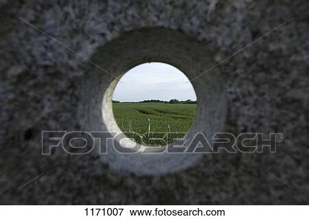 Stock Photo - A remote natural landscape seen through a hole in granite . Fotosearch