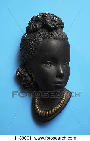 Stock Image - A retro wall hanging of a woman with a gold necklace. Fotosearch