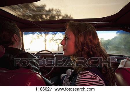 Stock Photo - A rockabilly couple in the front seat of a vintage car. Fotosearch