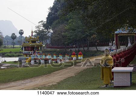 A row of Buddhist monk statues in a procession behind a Buddha statue, Hpa-An, Burma View Large Photo Image Stock Photo - A row of Buddhist monk statues in a procession behind a Buddha statue, Hpa-An, Burma. Fotosearch