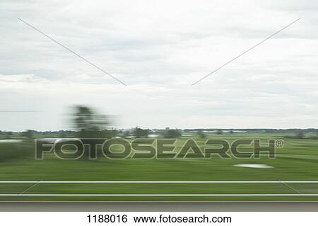 A rural landscape in blurred motion viewed from a moving train View Large Photo Image Stock Photograph - A rural landscape in blurred motion viewed from a moving train. Fotosearch
