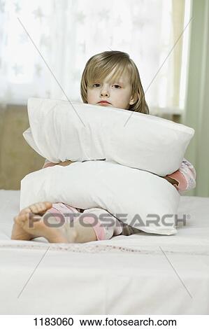 A sad looking little girl squeezing a pillow View Large Photo Image Stock Image - A sad looking little girl squeezing a pillow. Fotosearch