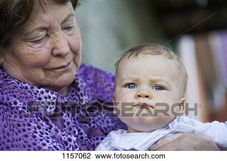 Stock Image - A senior woman holding a baby. Fotosearch
