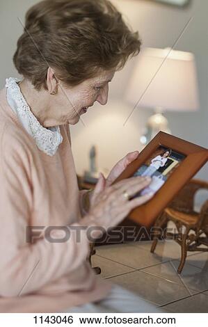A senior woman holding a picture frame View Large Photo Image Stock Photograph - A senior woman holding a picture frame. Fotosearch