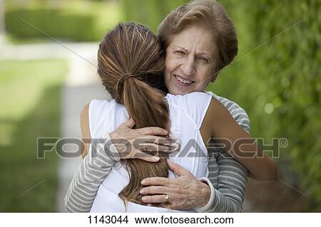 A senior woman hugging a young woman View Large Photo Image Picture - A senior woman hugging a young woman. Fotosearch