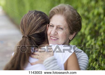A senior woman hugging a young woman View Large Photo Image Stock Image - A senior woman hugging a young woman. Fotosearch