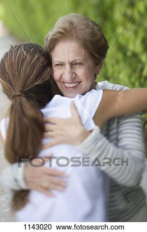 A senior woman hugging a young woman View Large Photo Image Stock Image - A senior woman hugging a young woman. Fotosearch