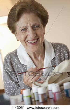 A senior woman painting on fabric View Large Photo Image Stock Image - A senior woman painting on fabric. Fotosearch