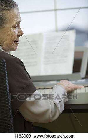 A senior woman sitting at piano View Large Photo Image Stock Photo - A senior woman sitting at piano . Fotosearch