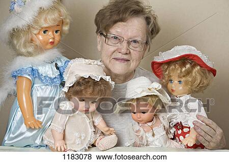 A senior woman with her collection of old-fashioned dolls View Large Photo Image Stock Photo - A senior woman with her collection of old-fashioned dolls. Fotosearch