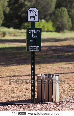 A sign and bin for pet waste in a park View Large Photo Image Stock Photo - A sign and bin for pet waste in a park. Fotosearch