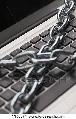 A thick metal chain wrapped around a laptop, close-up View Large Photo Image Picture - A thick metal chain wrapped around a laptop, close-up. Fotosearch