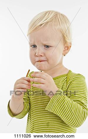 A toddler eating a pretzel stick View Large Photo Image Stock Photograph - A toddler eating a pretzel stick. Fotosearch