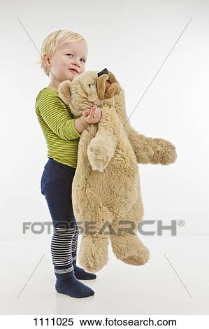 A toddler holding a teddy bear View Large Photo Image Stock Photography - A toddler holding a teddy bear. Fotosearch