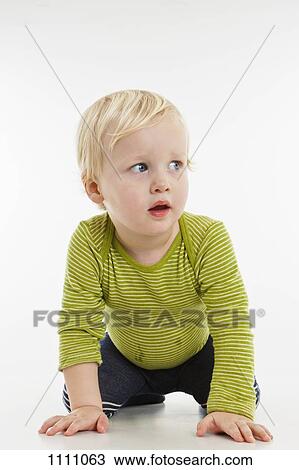 A toddler kneeling and looking away View Large Photo Image Stock Image - A toddler kneeling and looking away. Fotosearch