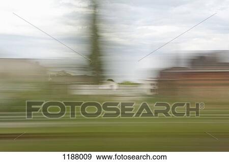 Stock Photo - A village in blurred motion viewed from a moving train. Fotosearch