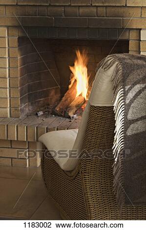 A wicker chair in front of a roaring fire View Large Photo Image Stock Image - A wicker chair in front of a roaring fire. Fotosearch