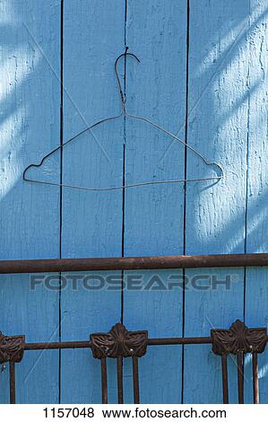 A wire coat hanger on a blue wall View Large Photo Image Stock Photo - A wire coat hanger on a blue wall. Fotosearch