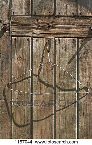 A wire coat hanger on a wooden wall View Large Photo Image Picture - A wire coat hanger on a wooden wall. Fotosearch