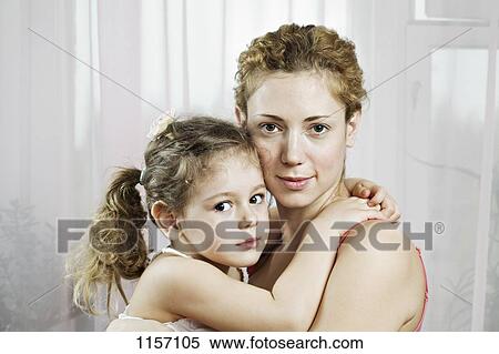A woman and a young girl embracing View Large Photo Image Stock Photography - A woman and a young girl embracing. Fotosearch