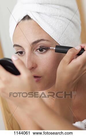Stock Image - A woman applying mascara. Fotosearch