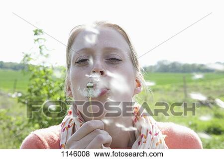 A woman blowing on a dandelion, close-up View Large Photo Image Stock Photo - A woman blowing on a dandelion, close-up. Fotosearch