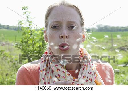 A woman blowing on a dandelion, close-up View Large Photo Image Stock Photo - A woman blowing on a dandelion, close-up. Fotosearch