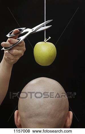 A woman cutting an apple on a string above the head of a man View Large Photo Image Stock Photo - A woman cutting an apple on a string above the head of a man. Fotosearch