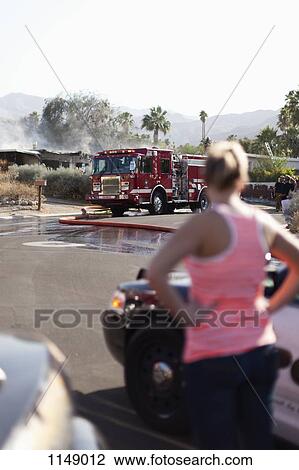 A woman looking at the scene of a burning house in a suburb View Large Photo Image Stock Image - A woman looking at the scene of a burning house in a suburb. Fotosearch