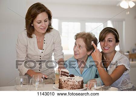 A woman serving cake for her mother and daughter View Large Photo Image Stock Image - A woman serving cake for her mother and daughter. Fotosearch