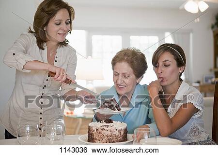 A woman serving cake for her mother and daughter View Large Photo Image Stock Photograph - A woman serving cake for her mother and daughter. Fotosearch