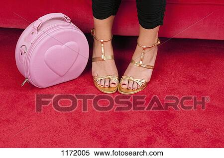 A woman wearing gold strappy heels (focus on feet) next to a pink purse View Large Photo Image Stock Photography - A woman wearing gold strappy heels (focus on feet) next to a pink purse. Fotosearch