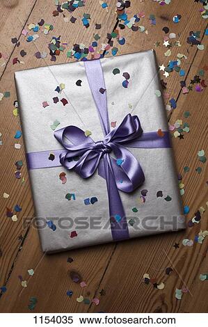 A wrapped present surrounded by confetti View Large Photo Image Stock Photography - A wrapped present surrounded by confetti. Fotosearch