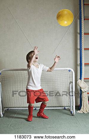 A young boy defending a goal while a ball flies towards him View Large Photo Image Stock Image - A young boy defending a goal while a ball flies towards him. Fotosearch