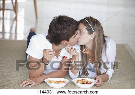 A young couple kissing while eating breakfast View Large Photo Image Stock Image - A young couple kissing while eating breakfast. Fotosearch