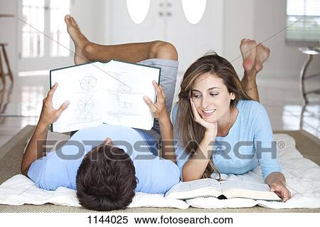 A young couple lying on the floor studying with textbooks View Large Photo Image Stock Photography - A young couple lying on the floor studying with textbooks. Fotosearch