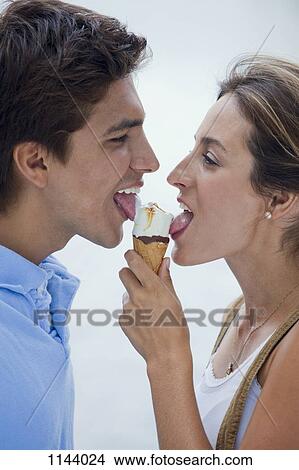 A young couple sharing an ice cream cone View Large Photo Image Picture - A young couple sharing an ice cream cone. Fotosearch